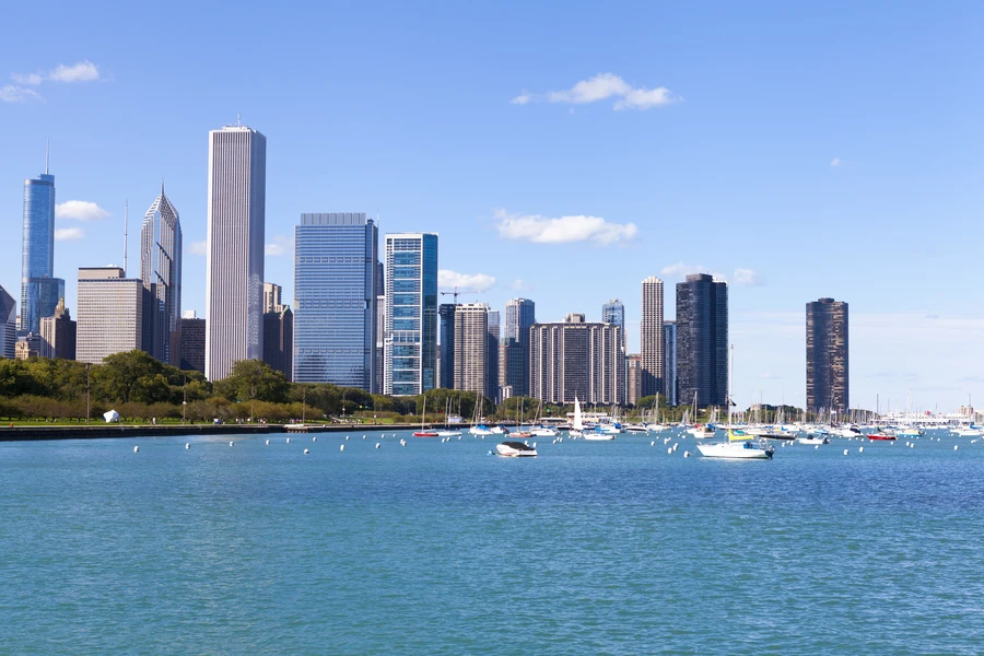 Millennium Park's Cloud Gate (The Bean) reflecting Chicago skyline and Chicagoans gathering