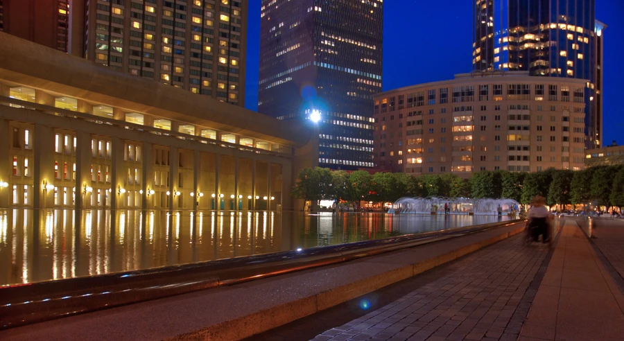 Lincoln Center at night with theater lights reflecting on plaza