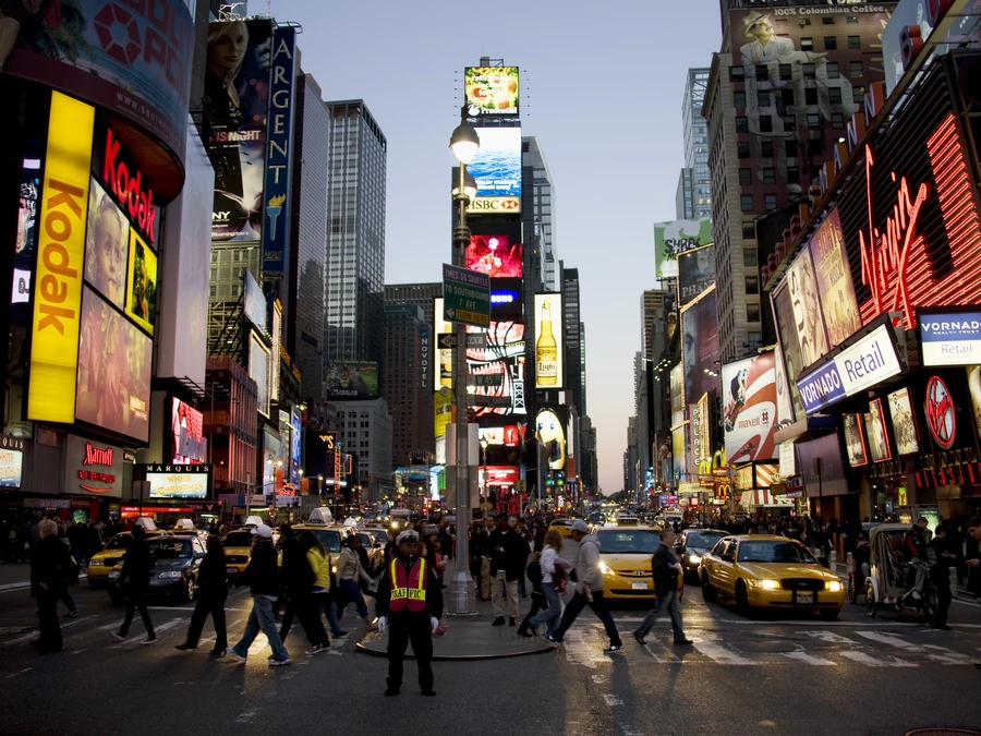 Broadway at dusk with theater marquees and crowds